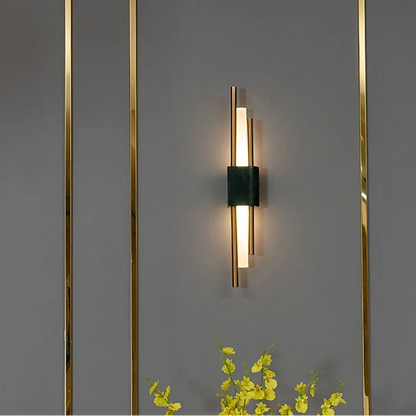 Modern wall-mounted light fixture on a gray wall with decorative elements.